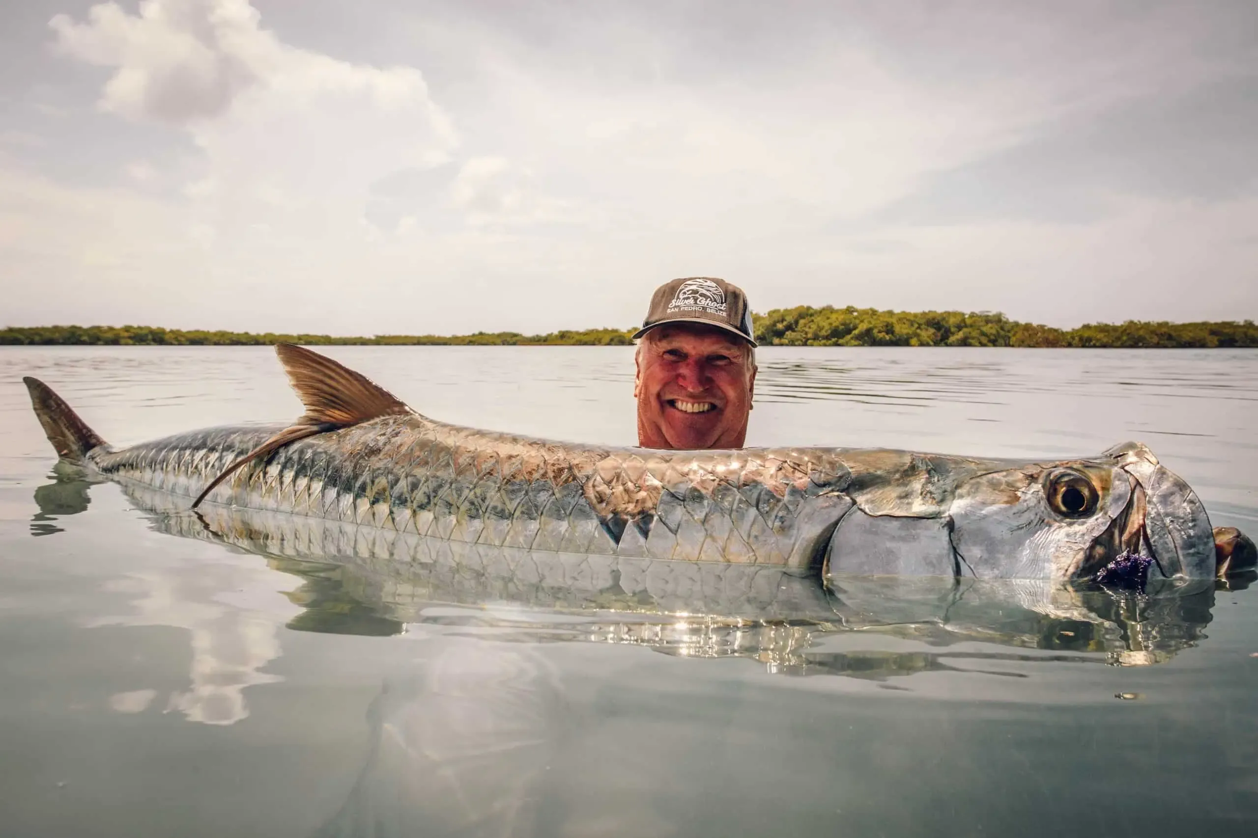 Tarpon jumping on a fly rod near Ambergris Caye, Belize — spring migration fish on the flats