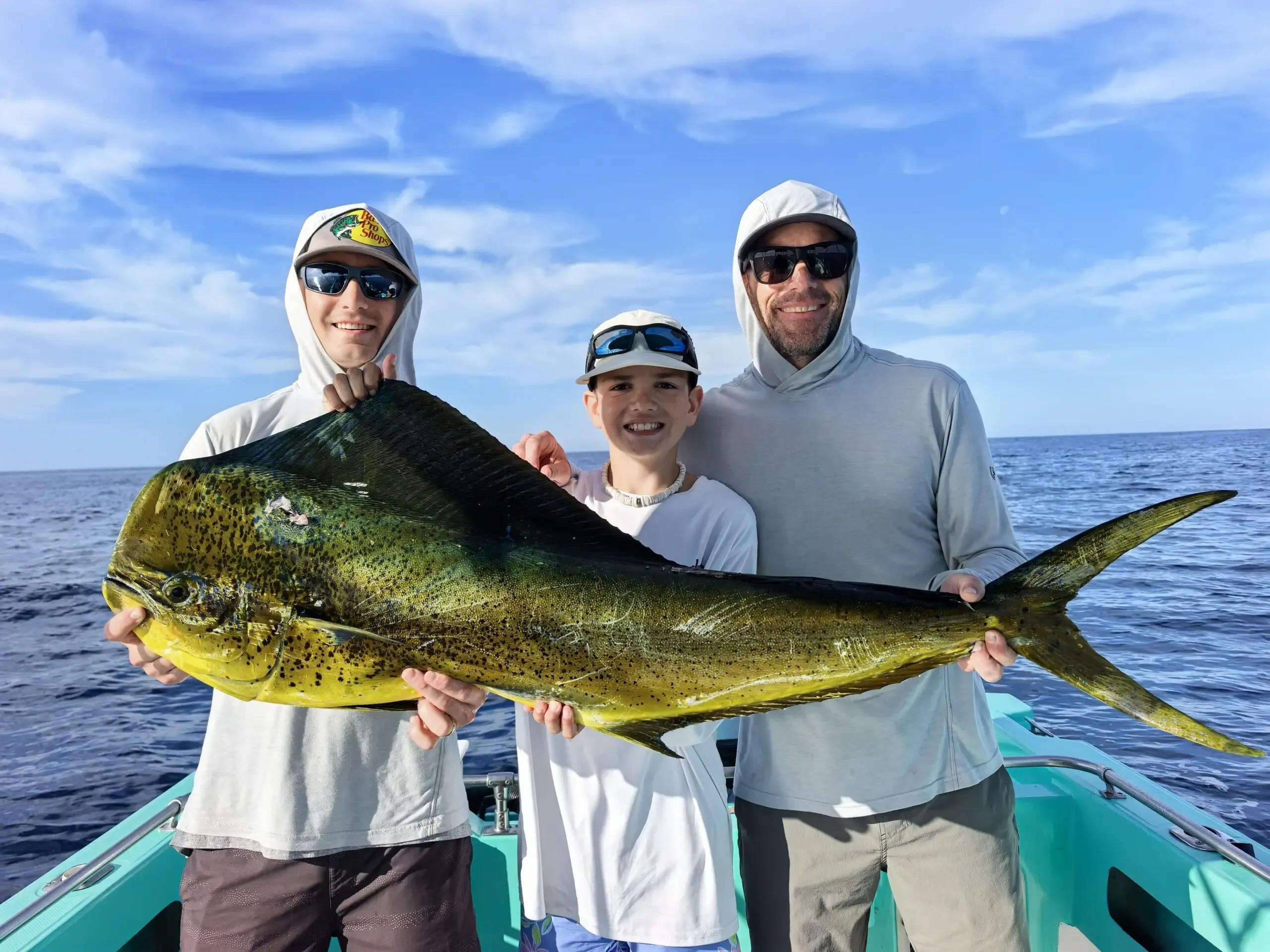 Dorado caught offshore near Placencia, Belize — vivid iridescent colors alongside the hull